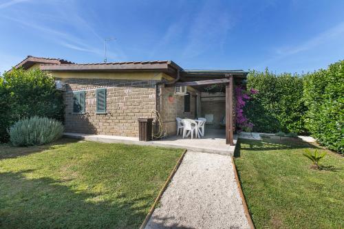 a small brick house with a table in a yard at Agriturismo Torre Flavia in Ladispoli
