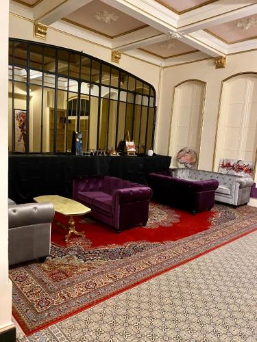 a living room with purple furniture and a red rug at Salon Boyer in Épernay