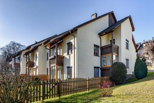a large white house with a wooden fence at Apartment See und Traunsteinblick in Altmünster