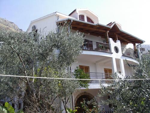 a white house with trees in front of it at Guest house Živković in Sveti Stefan