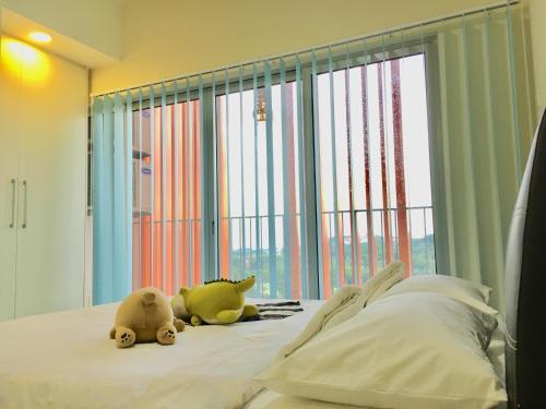 a bedroom with two stuffed animals sitting on a bed at Suria Jelutong Studio by BeeStay in Shah Alam