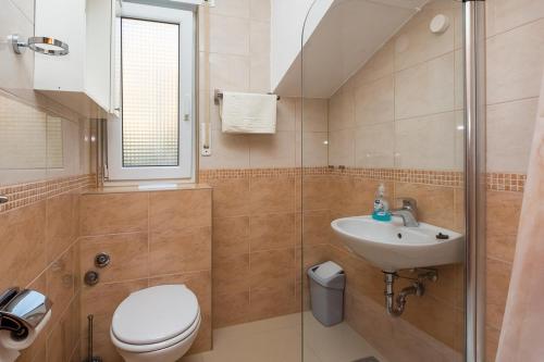 a bathroom with a toilet and a sink and a shower at Apartments Toni 2000 in Podstrana