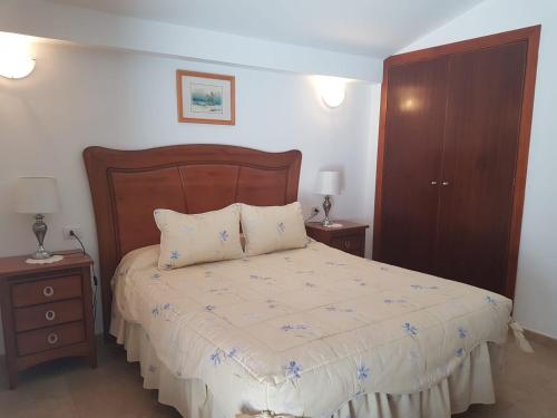 a bedroom with a large bed with two night stands at Vivienda Vacacional la Palmera in Los Cancajos