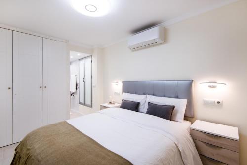 een slaapkamer met een groot bed met witte muren bij Beach Front Apartment-1st Line in Marbella