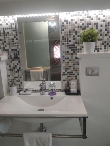 a bathroom with a sink and a mirror at H5-5H Luxury Room in Maranello