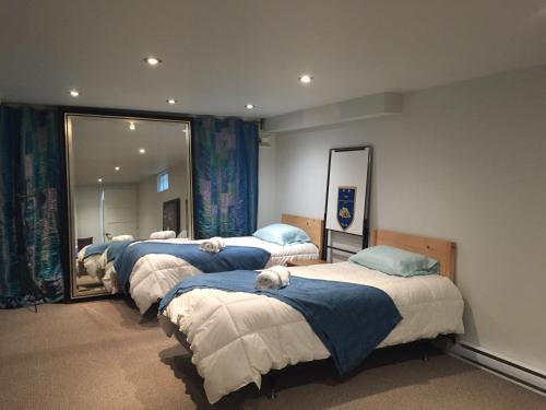 a row of beds in a room with mirrors at Gîte Zazen in Mont-Laurier