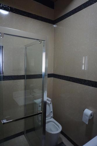 a bathroom with a toilet and a glass shower stall at Holiday Hire Fiji in Lautoka