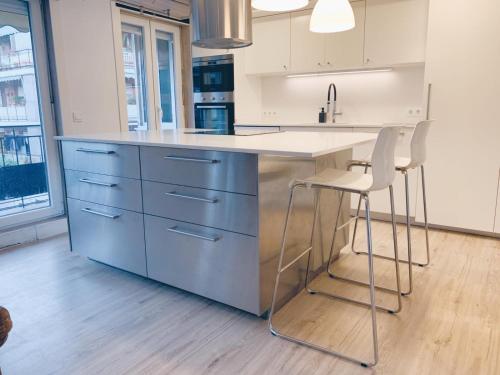 a kitchen with a blue island with stools in it at New Apartament close to IFEMA-AEROPUERTO in Madrid
