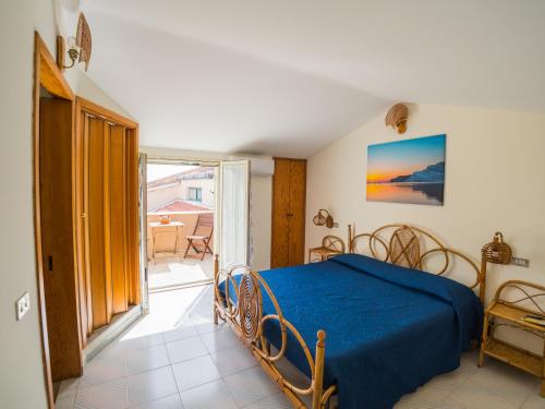 una camera con letto blu e balcone di La Casa di Pippo a Agrigento