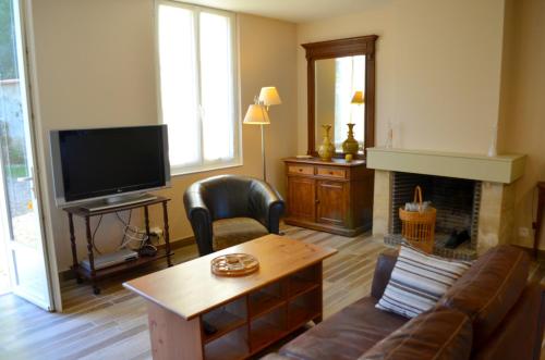 Una sala de estar con un sofá y una chimenea. en Le Gîte des Sureaux, en Rarécourt