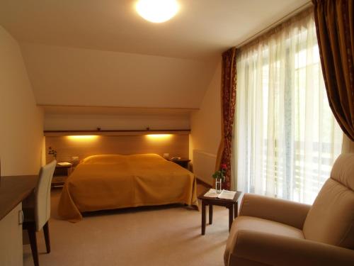 - une chambre avec un lit jaune et un canapé dans l'établissement Vila Park B&B - Adults Only, à Bohinj