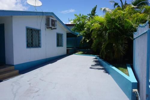 a driveway leading to a house with palm trees at Holiday Hire Fiji in Lautoka