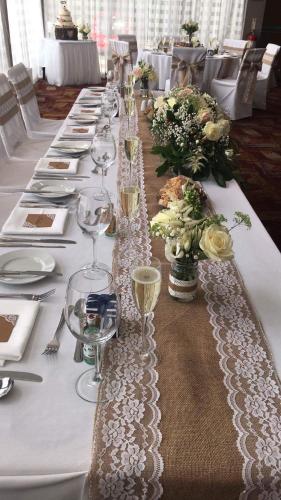 a long table with wine glasses and flowers on it at Beamish Park Hotel in Beamish