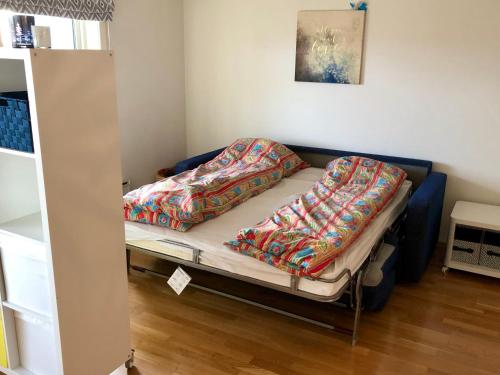 a bed with two blankets on it in a room at Sjønær leilighet med gangavstand til strand i Larvik in Larvik