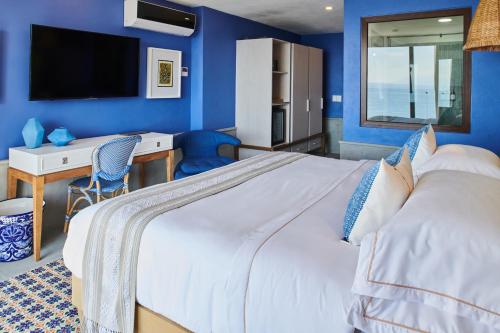 a bedroom with a large bed with a blue wall at Hotel Luxury Patio Azul in Puerto Vallarta