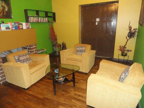 a living room with three chairs and a coffee table at Hospedaje Turistico Recoleta in Cusco