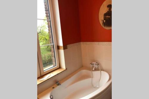 baño con bañera y ventana en Appartement dans un bâtiment historique, en Thorembais-Saint-Trond