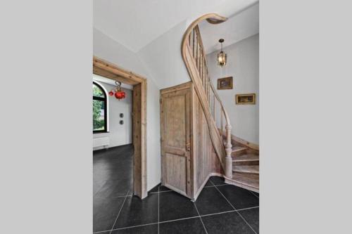 a staircase in a house with a wooden door at Appartement dans un bâtiment historique in Thorembais-Saint-Trond