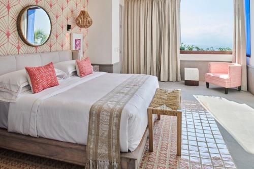 a bedroom with a large bed and a mirror at Hotel Luxury Patio Azul in Puerto Vallarta