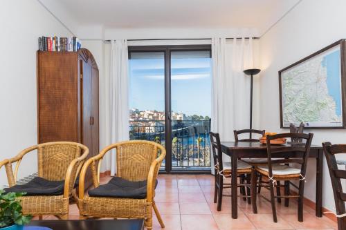 a dining room with a table and chairs and a balcony at Regina's Banyuls - Top view in Banyuls-sur-Mer