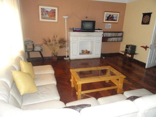 a living room with a white couch and a coffee table at Hospedaje Turistico Recoleta in Cusco