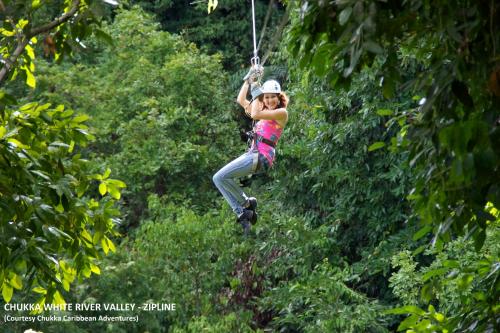 a woman on a zip line in the jungle at Sea Shell Palms, Ocho Rios in Ocho Rios