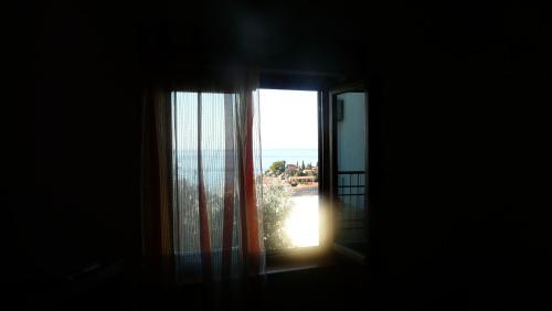 an open window with a view of the ocean at Guest house Živković in Sveti Stefan