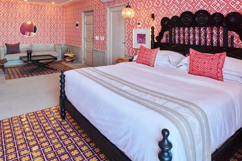 a bedroom with a large bed with red walls at Hotel Luxury Patio Azul in Puerto Vallarta