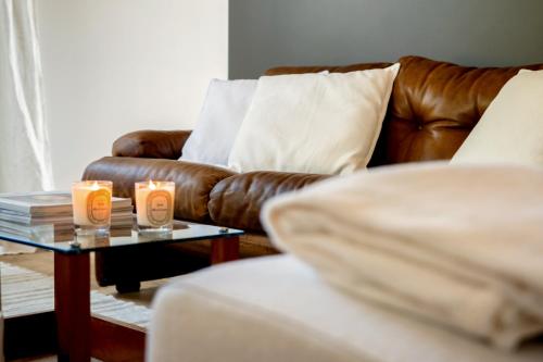 a living room with a couch and candles on a table at CasaVostra - Ambience Suites in Ostra Vetere