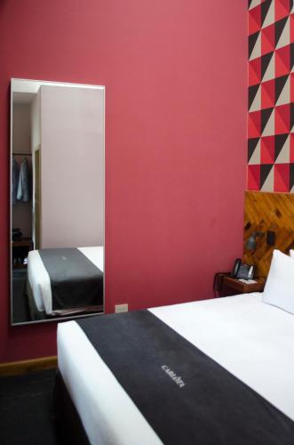 a hotel room with a bed and a mirror at Carlota Sustainable Design Hotel in Quito