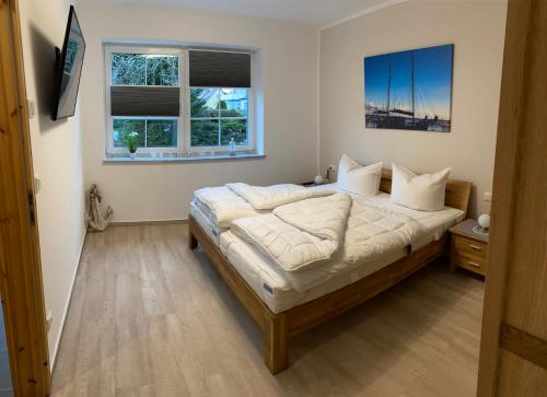 um quarto com uma cama grande e 2 janelas em Fewo Barth em Barth