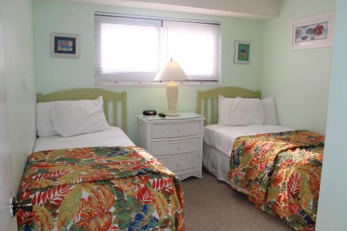 a bedroom with two beds and a table with a lamp at Myrtle Beach Resort in Myrtle Beach