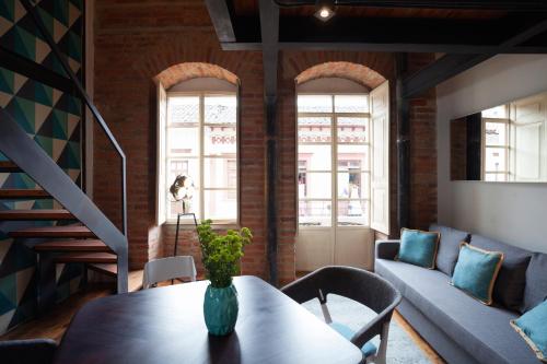 a living room with a table and a couch at Carlota Sustainable Design Hotel in Quito