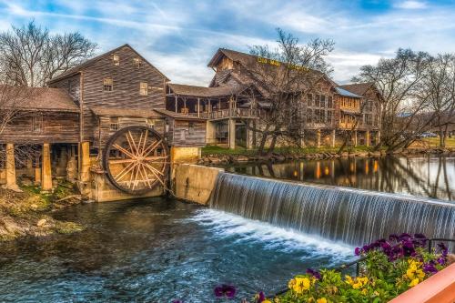 a mill and water wheel in front of a house at Nature's Paradise in Pigeon Forge