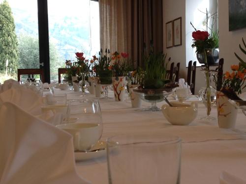 długi stół z białymi daniami i kwiatami na nim w obiekcie Frühmesserhaus Refugium zu Sanct Kassian w mieście Lagundo
