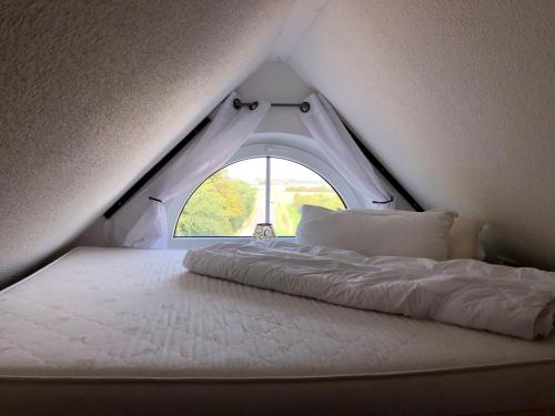 a white bed in a room with a window at Inselloft-Fehmarn in Fehmarn