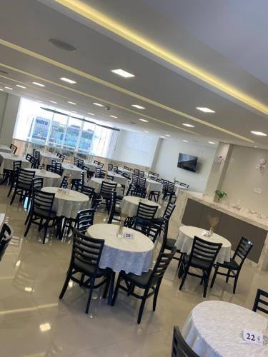 a dining room with white tables and chairs at Hotel Catarina in São Miguel dʼOeste