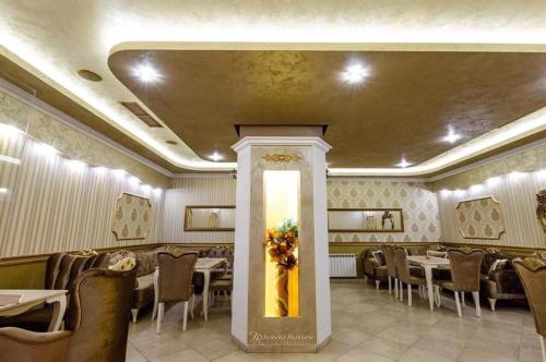 a dining room with tables and chairs and a painting at Hotel Kristal in Zlatograd