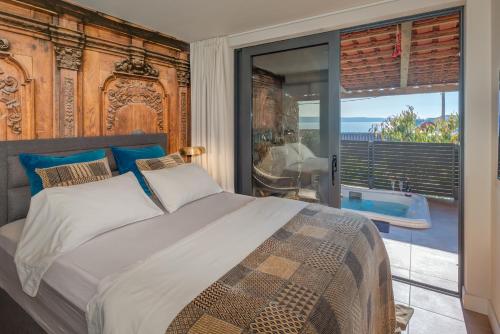 een slaapkamer met een bed en een glazen schuifdeur bij Paradiso Apartment with Private Jacuzzi and Terrace in Trogir