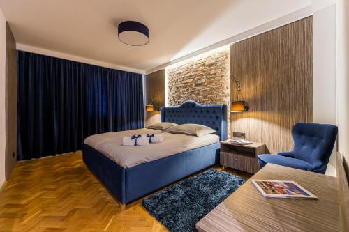 1 dormitorio con 1 cama azul y 1 silla azul en Grelewicz Apartments-MyPlace, en Toruń
