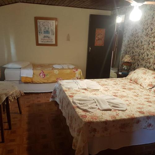 a bedroom with two beds with towels on them at Nova Pousada Chamonix in Teresópolis