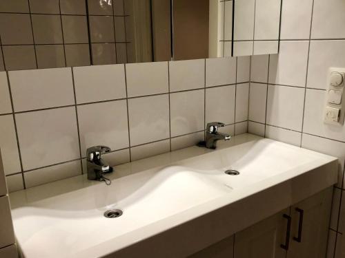 a bathroom sink with two faucets and a mirror at Sjønær leilighet med gangavstand til strand i Larvik in Larvik