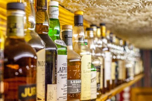 a row of bottles of alcohol on a shelf at Seaview John O Groats Hotel in John O Groats