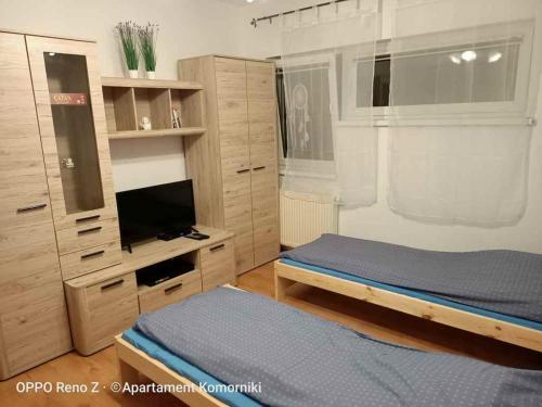 a bedroom with a bed and a flat screen tv at Apartament Komorniki in Komorniki