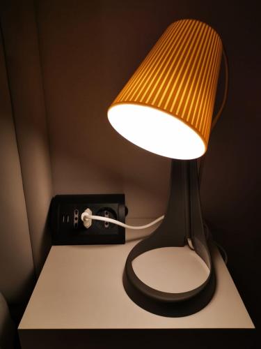 a lamp sitting on a table next to a clock at Villa Zen 2 in Padova