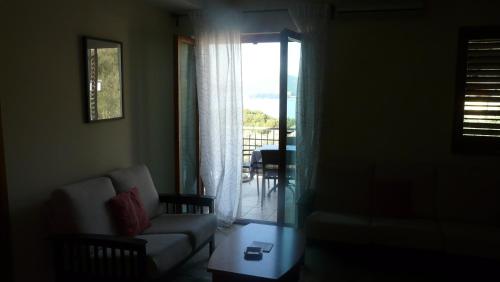 a living room with a couch and a table and a window at Guest house Živković in Sveti Stefan