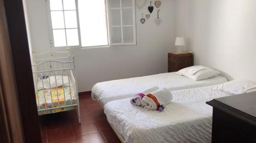 a room with two beds and a crib at Casa da Azinheira in Farelos de Baixo