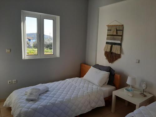a bedroom with a bed and two windows at Miramar Complex - Korfos in Korfos