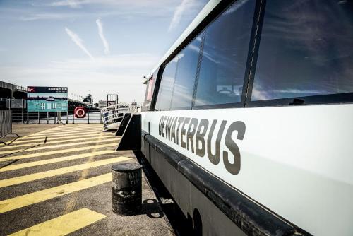 a white bus parked in a parking lot at Vakantiewoning De Gulden Sleutels in Kruibeke