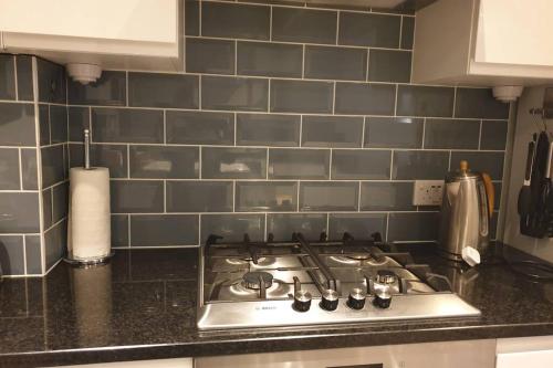 a kitchen with a stove top oven in a kitchen at Spacious 2 bed in gated community up to 6 guests in London